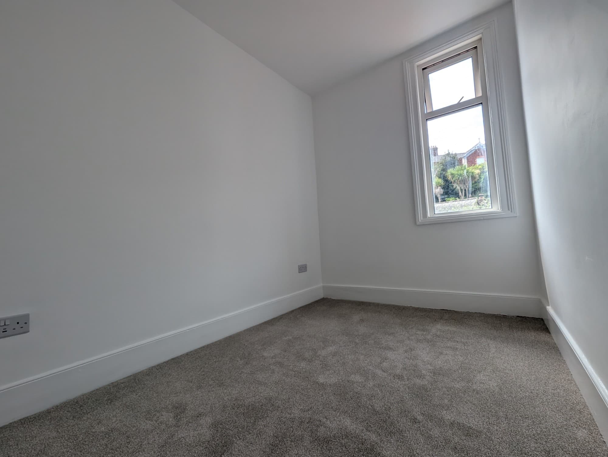 Freshly redecorated bedroom with new carpet, painted walls and sash window